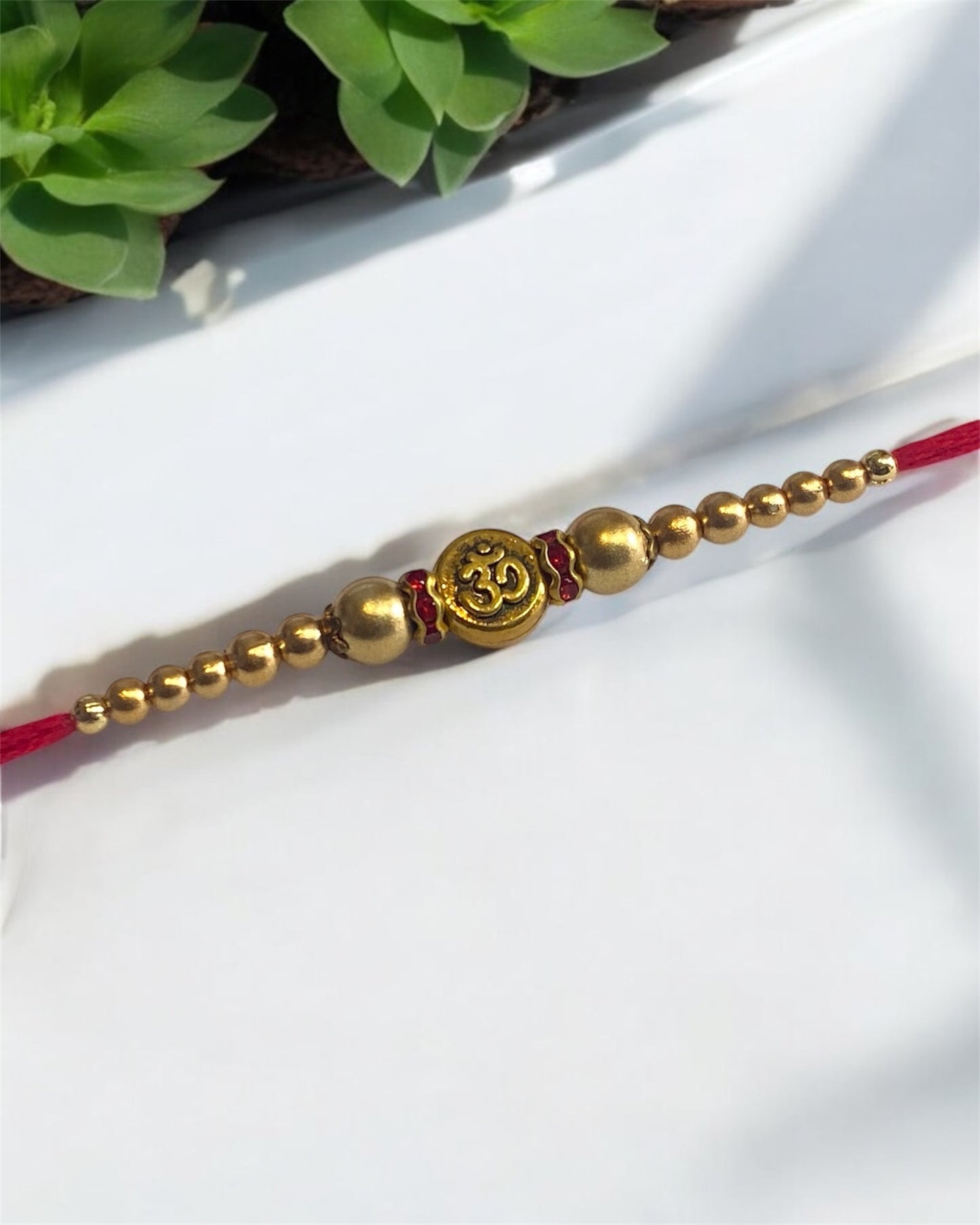 Designer Rakhi 2025 – Om Beads Rakhi with Glass & Golden Beads on Red Thread | Raksha Bandhan for Brother